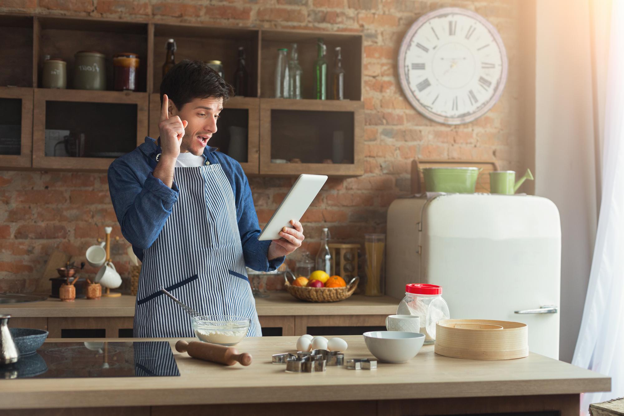 Person answering customer messages beside a kitchen