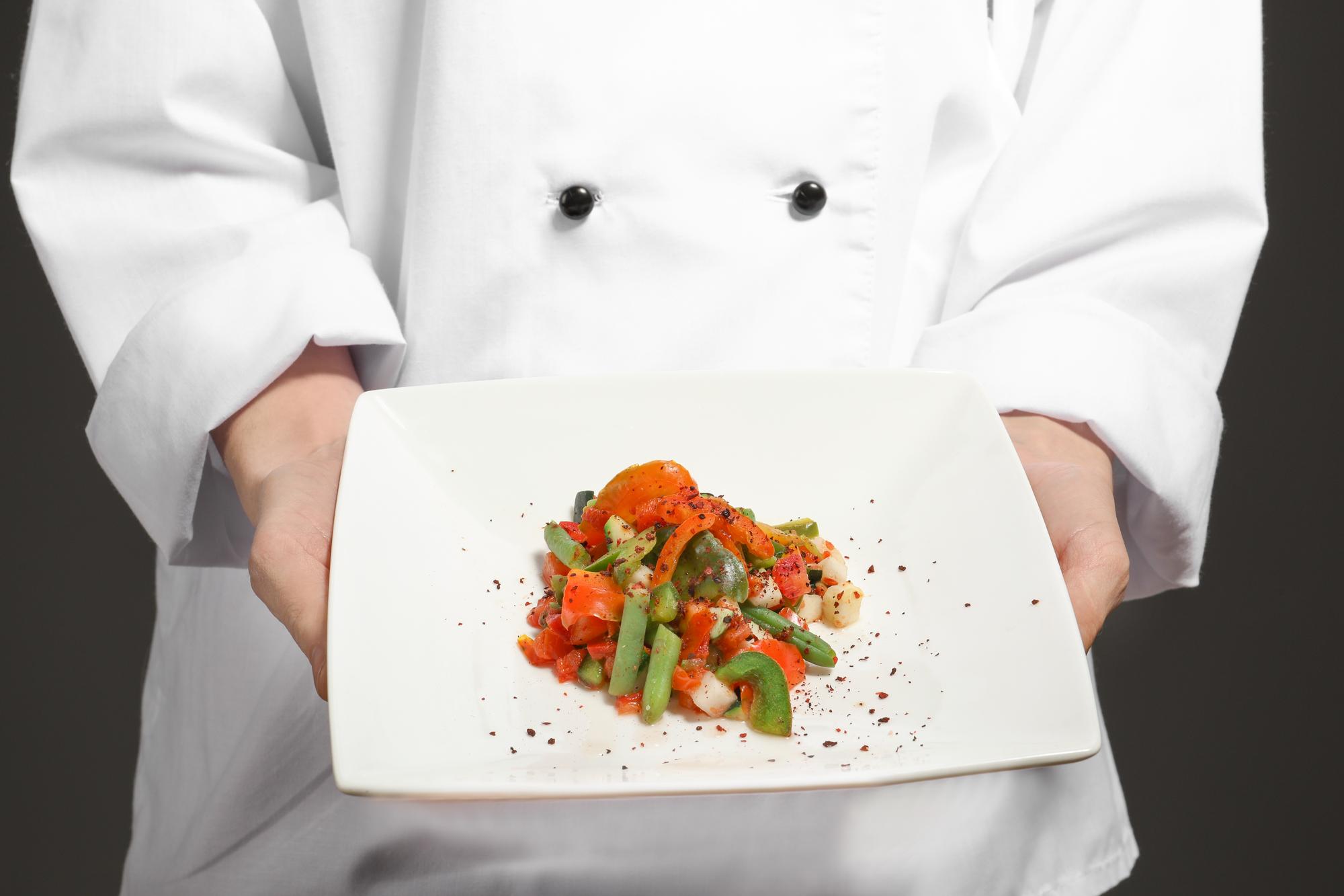 Chef teaching an online class with plated dishes